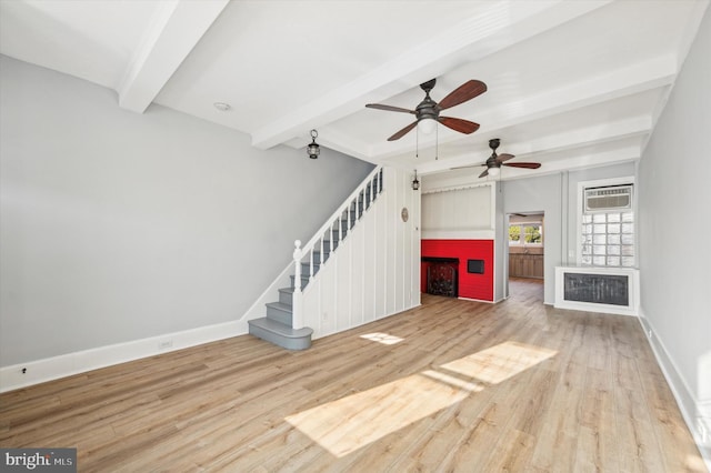 unfurnished living room with a wall unit AC, ceiling fan, hardwood / wood-style floors, and beamed ceiling