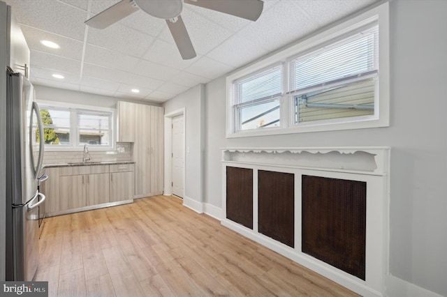 kitchen with a wealth of natural light, light brown cabinets, sink, and stainless steel refrigerator