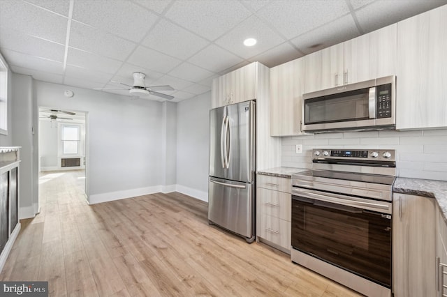 kitchen featuring backsplash, stainless steel appliances, light hardwood / wood-style flooring, and a drop ceiling