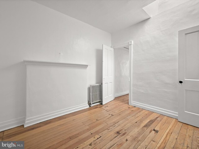 spare room with radiator and light hardwood / wood-style flooring