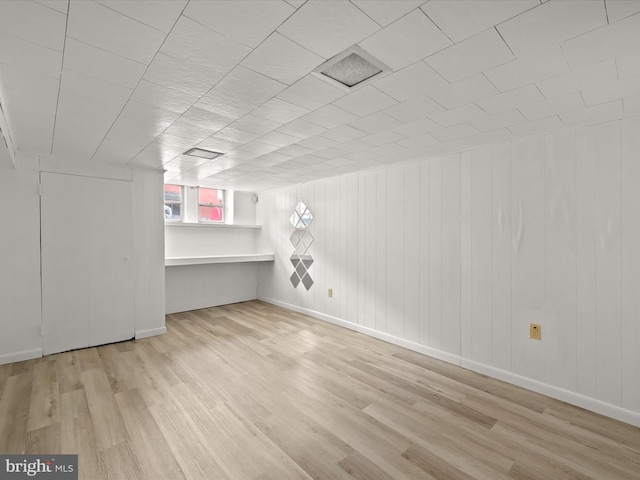 bonus room with wood walls and light hardwood / wood-style flooring