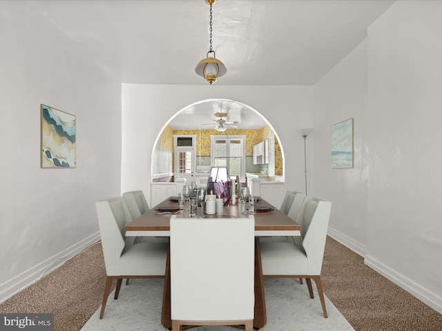 carpeted dining space featuring ceiling fan