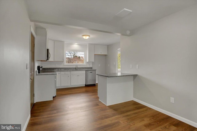 kitchen with dark hardwood / wood-style flooring, light stone countertops, dishwasher, and white cabinets