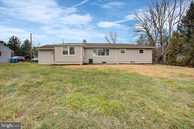 rear view of property featuring a lawn and central AC