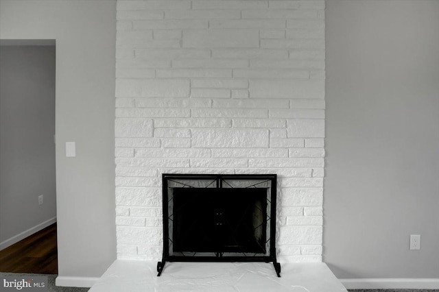 interior details featuring hardwood / wood-style flooring and a stone fireplace