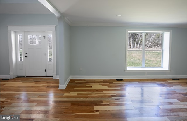 foyer with crown molding and hardwood / wood-style flooring