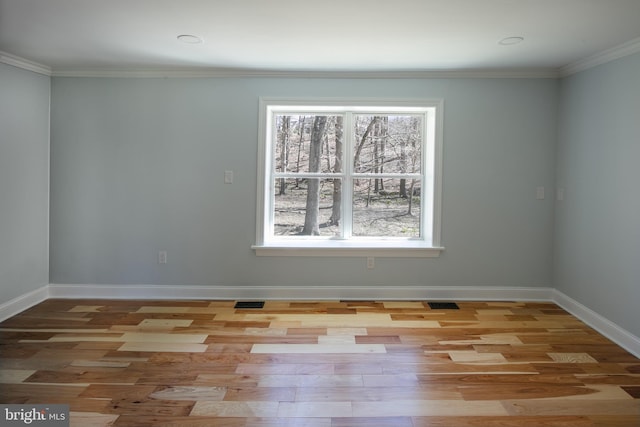 empty room featuring crown molding and light hardwood / wood-style flooring