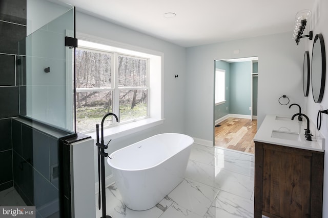 bathroom featuring hardwood / wood-style floors, vanity, and a tub to relax in