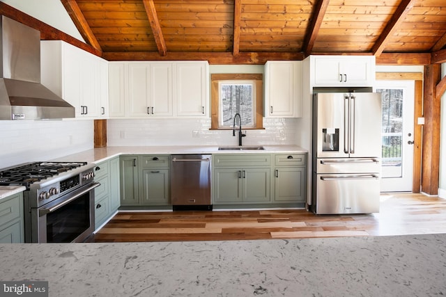 kitchen with sink, wall chimney exhaust hood, vaulted ceiling with beams, light hardwood / wood-style flooring, and high end appliances