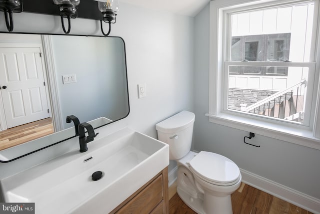 bathroom with vanity, toilet, and wood-type flooring