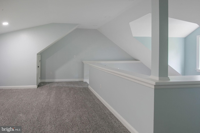 additional living space featuring carpet flooring and vaulted ceiling