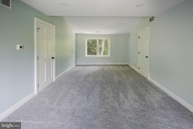 carpeted empty room featuring lofted ceiling