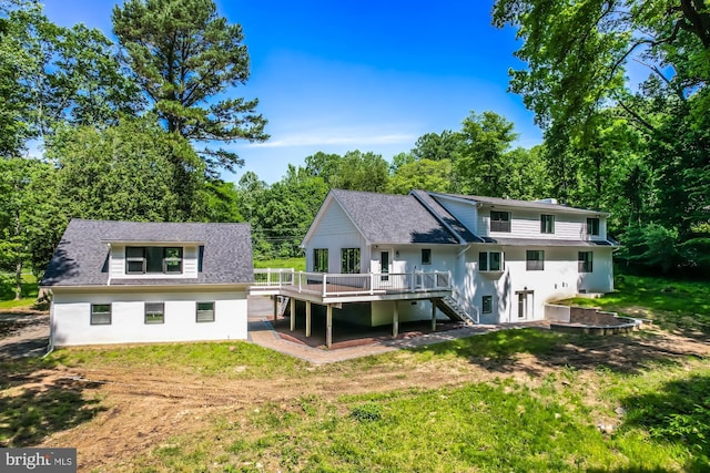 back of property featuring a lawn and a wooden deck