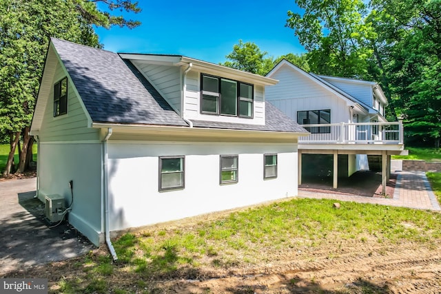 rear view of house featuring a wooden deck, a yard, and ac unit