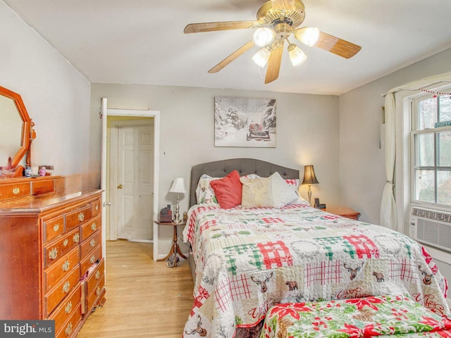 bedroom featuring ceiling fan, cooling unit, and light wood-type flooring