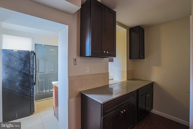 kitchen with light tile patterned floors and dark brown cabinets