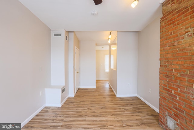 spare room featuring ceiling fan, rail lighting, and light hardwood / wood-style flooring