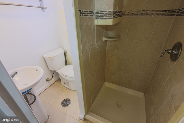 bathroom featuring tiled shower, toilet, and tile patterned floors