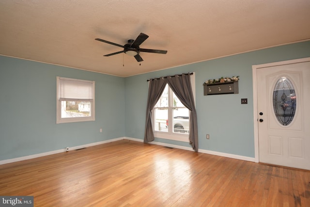 entryway featuring ceiling fan, light hardwood / wood-style flooring, and a textured ceiling