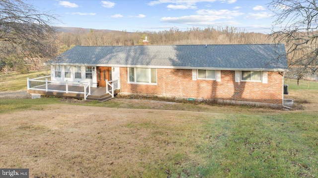 ranch-style house featuring a front lawn and a deck