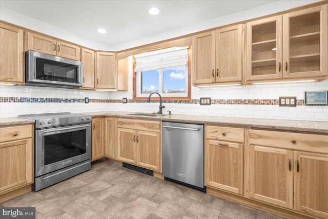 kitchen featuring decorative backsplash, light stone countertops, stainless steel appliances, sink, and light brown cabinets