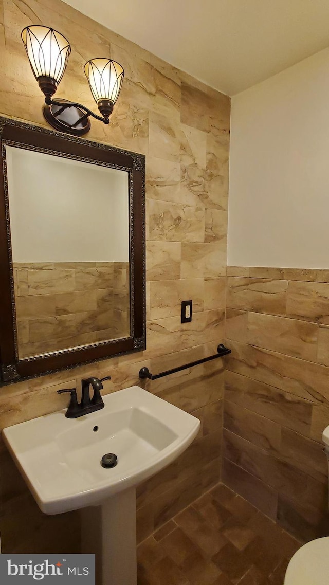 bathroom featuring tile walls and sink