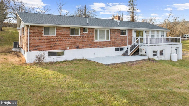 rear view of property with cooling unit, a patio area, and a lawn