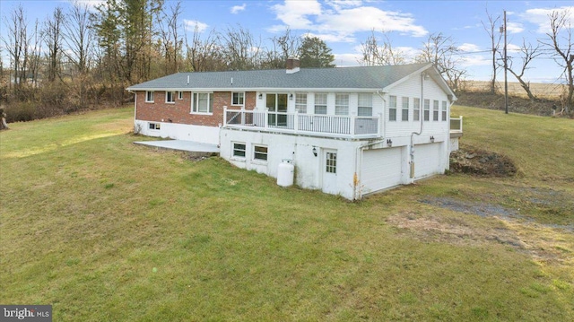 back of house featuring a lawn, a wooden deck, and a garage