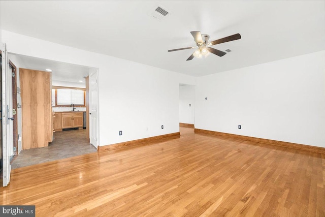 unfurnished room with ceiling fan, light hardwood / wood-style flooring, and sink