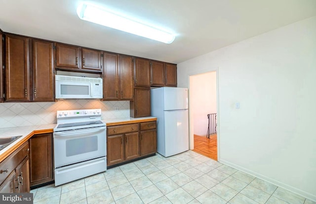 kitchen featuring decorative backsplash and white appliances