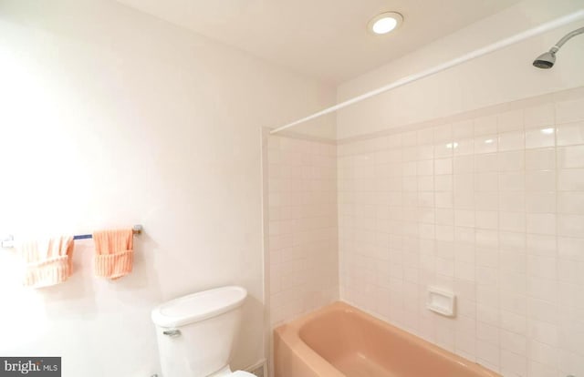 bathroom featuring tiled shower / bath combo and toilet