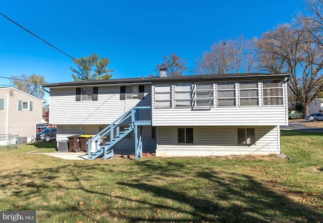 rear view of house with a yard, cooling unit, and a sunroom