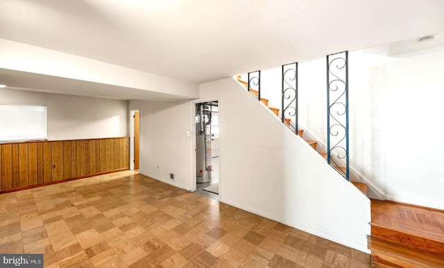 interior space with wood walls and light parquet floors