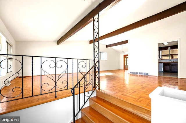 staircase featuring lofted ceiling with beams and parquet floors