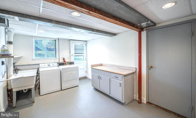 laundry area featuring separate washer and dryer and cabinets