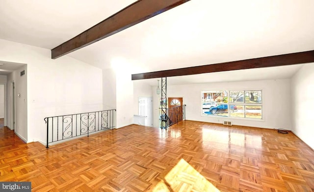 unfurnished living room featuring beam ceiling and light parquet flooring