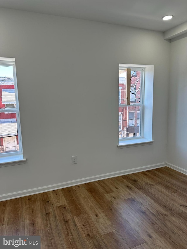 unfurnished room with hardwood / wood-style flooring and a wealth of natural light