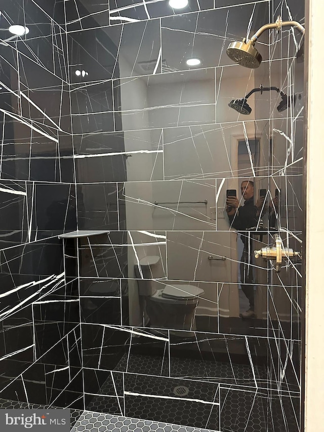 interior space featuring tile patterned floors, a tile shower, and tile walls