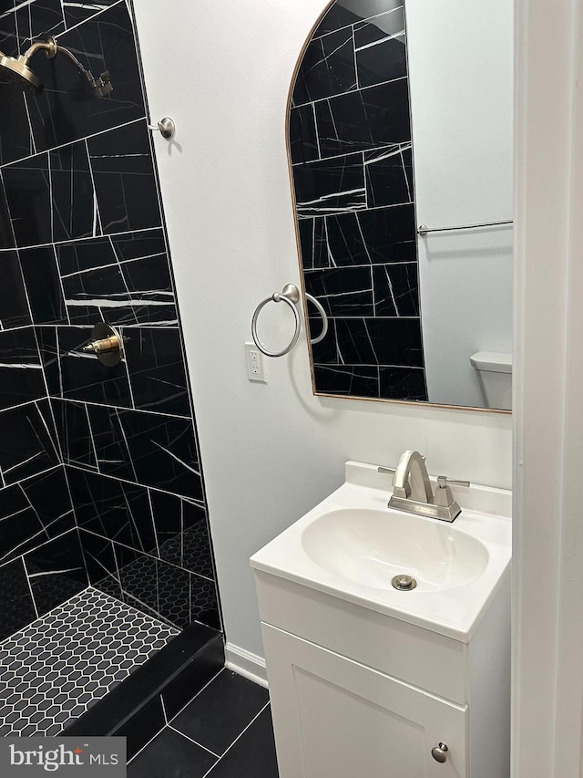 bathroom featuring tile patterned flooring, vanity, and tiled shower