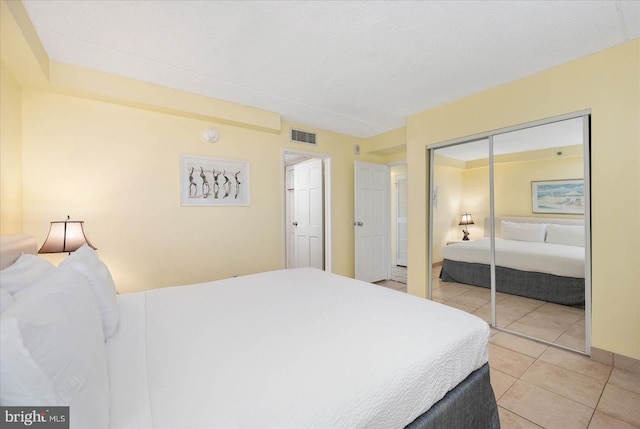 bedroom featuring a closet, a textured ceiling, and tile patterned flooring