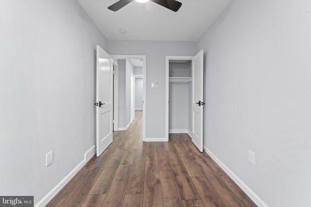 unfurnished bedroom with ceiling fan and dark wood-type flooring