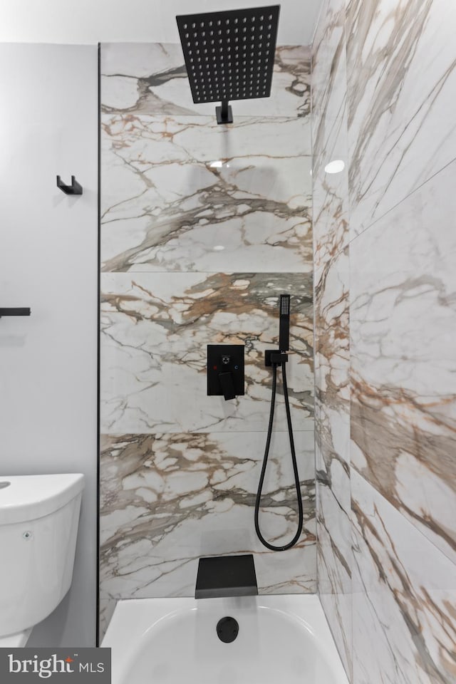 bathroom featuring toilet and tiled shower