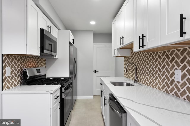 kitchen featuring white cabinets, sink, light stone countertops, and stainless steel appliances