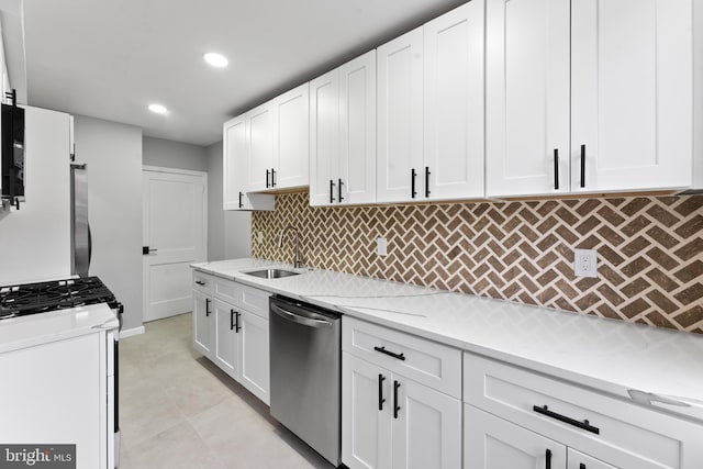 kitchen with dishwasher, backsplash, sink, light stone counters, and white cabinetry