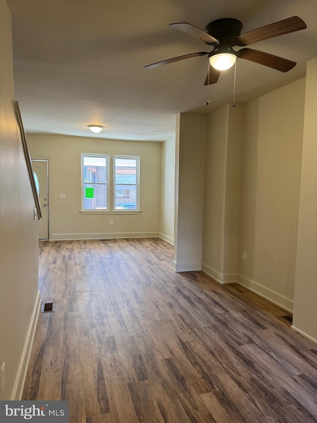 spare room with ceiling fan and dark wood-type flooring