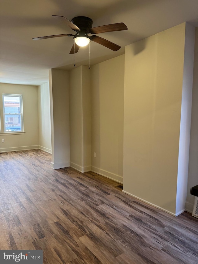 spare room with ceiling fan and dark wood-type flooring