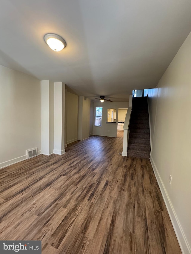 unfurnished living room featuring ceiling fan and dark hardwood / wood-style floors