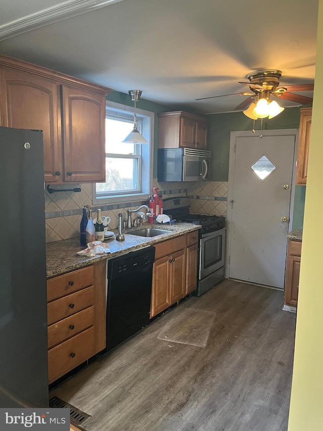 kitchen featuring ceiling fan, sink, dark wood-type flooring, backsplash, and black appliances