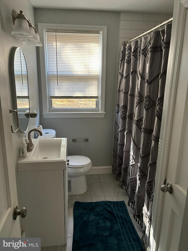 bathroom featuring vanity, toilet, and walk in shower