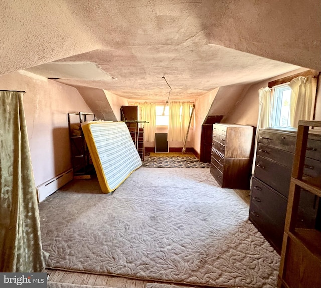 bonus room featuring a textured ceiling, carpet, a healthy amount of sunlight, and a baseboard radiator